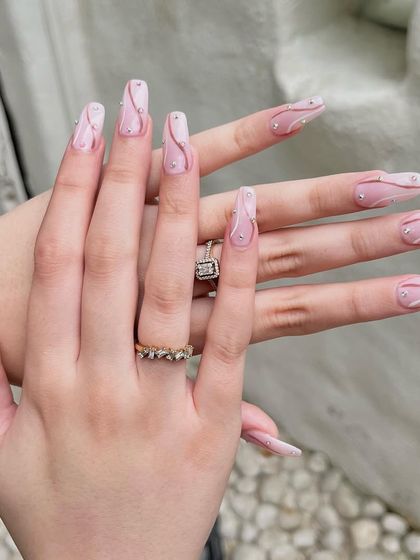 A full view of the elegant swirl and rhinestone nails, showing how the design flows across both hands.