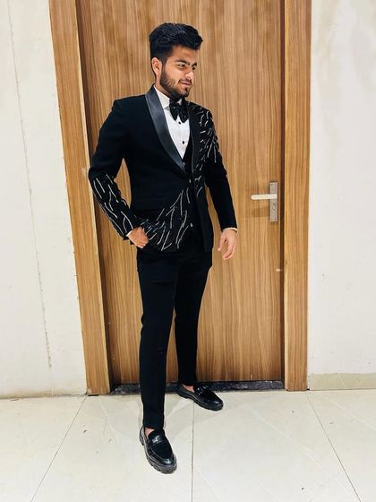 Another angle of the black suit with asymmetrical embroidery, showcasing its unique design and tailored fit.