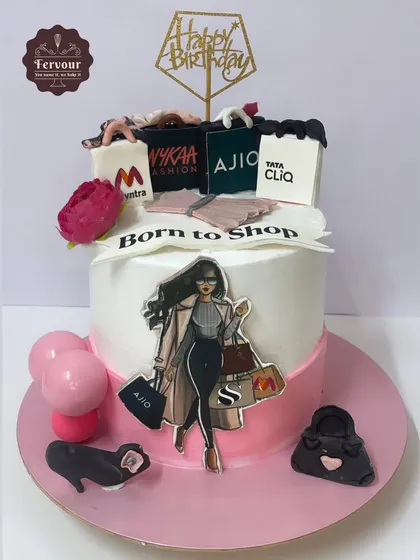A "Born to Shop" fashion theme cake for a shopaholic. This vanilla strawberry cake is decorated with edible shopping bags from popular Indian brands like Myntra, Ajio, and Nykaa.