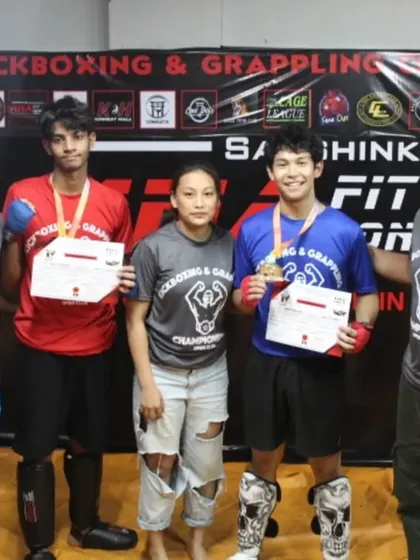 Our coaches with two medal-winning fighters at the MFC Series 2, showcasing the success of our kickboxing program.
