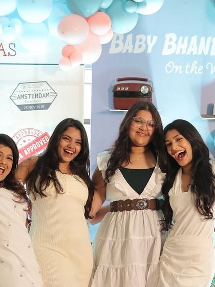 Friends having a blast at the travel-themed photo booth. The backdrop, with its visa stamp details and pastel balloons, was a popular spot for photos all day long.