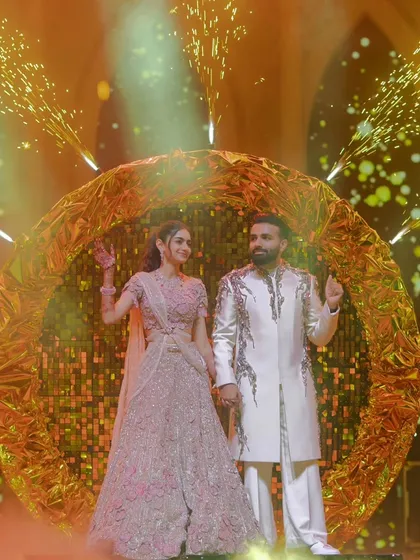 Framed by a golden halo and sparkling cold pyros, the couple makes a picture-perfect entrance. This is an example of how I use bespoke structures to create unique photo opportunities.