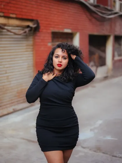 A duplicate of image 144, this powerful portrait in a black dress is set against a gritty urban alley, creating a moody and expressive shot.