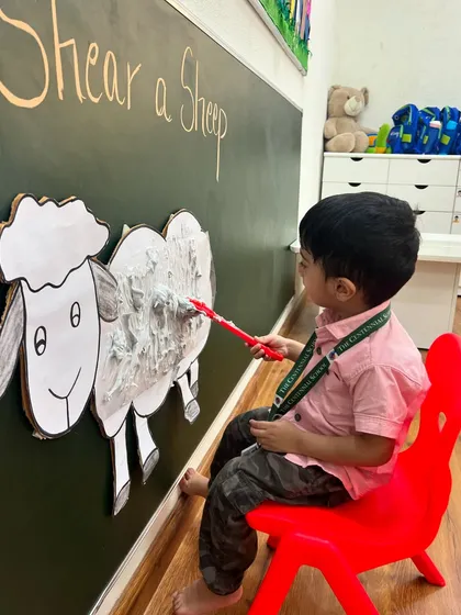 Look at the focus. This little one is learning about farm animals and their characteristics through a hands-on shearing activity that is both fun and educational.