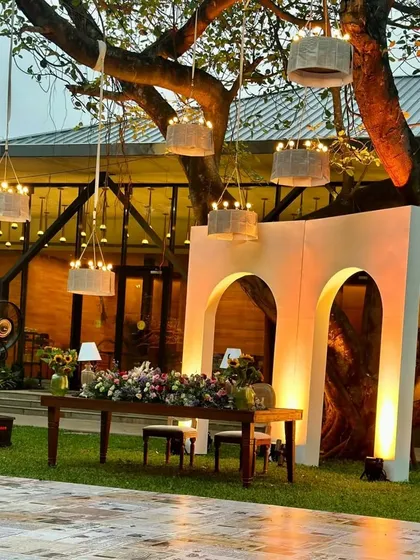 For this evening reception, we designed a romantic outdoor setting under a large tree. A custom-built backdrop with soft lighting created a focal point for the head table, while hanging lanterns provided a warm, magical glow.