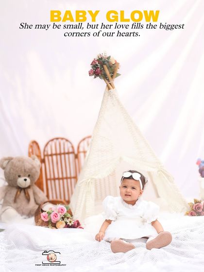 A beautiful portrait celebrating the "Baby Glow" of turning one. The little girl sits in front of a lace teepee, surrounded by soft props, looking like a little angel.