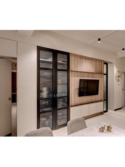 The living and dining area for a young family, where we blended wood textures, fluted panels, and integrated storage to create a space that is stylish, organized, and welcoming.