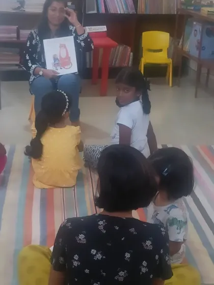 Another view of the storytelling session, showing a mix of toddlers and older children enjoying the story together.