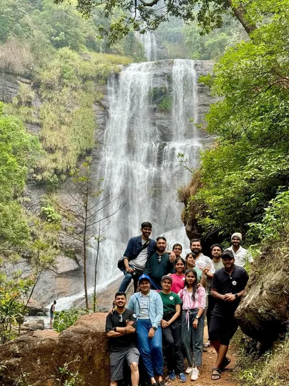 A group photo from our customized Chikmagalur trip, with the beautiful Hebbe falls in the background.