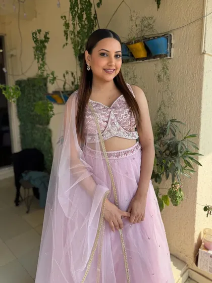 A full-length view of the bride in her lilac lehenga. The soft glam makeup perfectly complements the dreamy, pastel outfit.
