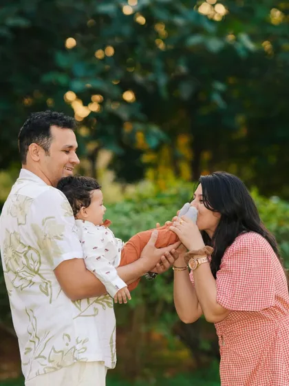 A playful and tender moment between parents and their baby during an outdoor family photoshoot. The mother kissing her baby's foot is a perfect example of the candid love I aim to capture.