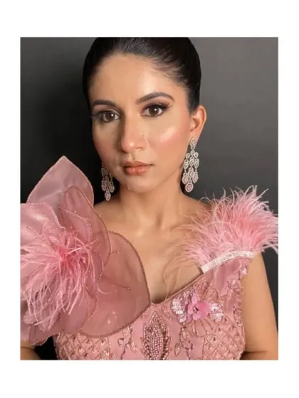 A close-up of the unique shoulder design of the pink gown.