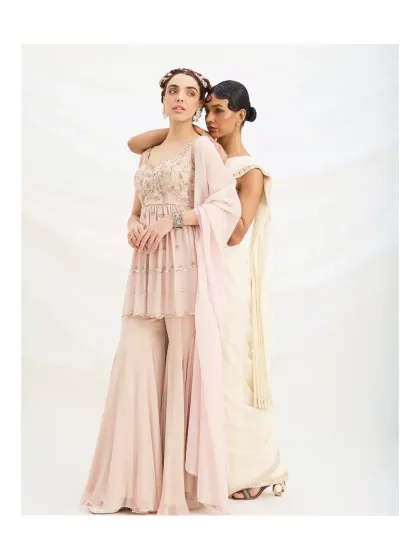 A light and fluid pastel sharara set, perfect for daytime celebrations. The tiered peplum top is embellished with delicate embroidery, offering a look that is both feminine and modern.