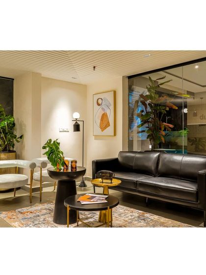 A minimal seating arrangement in the clubhouse lounge, designed to encourage movement and interaction. The black leather sofa and modern armchairs create a chic and comfortable spot for residents to gather.