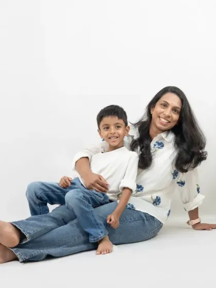 A loving portrait of a mother and her son. The minimalist white setting allows their warm smiles and connection to be the main focus.