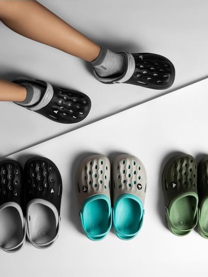 A creative composition showing clogs on a model's feet and arranged in a pattern below. This is a playful way to display multiple product colors.