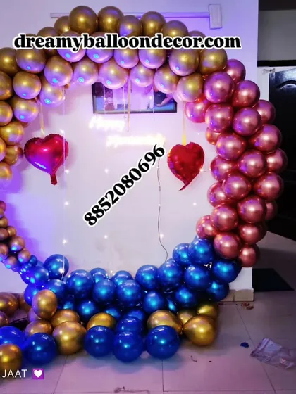 A bold and stylish balloon ring decoration. The mix of metallic gold, blue, and chrome pink balloons, along with fairy lights and heart accents, creates a modern and eye-catching backdrop.