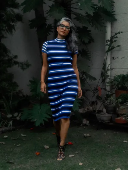 A full-length shot of the striped dress, showing its flattering, body-hugging silhouette.