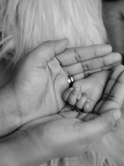 Your hand in mine, forever. This close-up black and white shot of a baby's hand in their parent's is a powerful symbol of your lifelong bond.