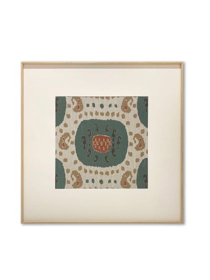 A single, beautiful section of a rug, framed with a wide, off-white mat and a thin metal frame with a wood-like finish. This classic presentation elevates the textile, making it feel like a fine art print.