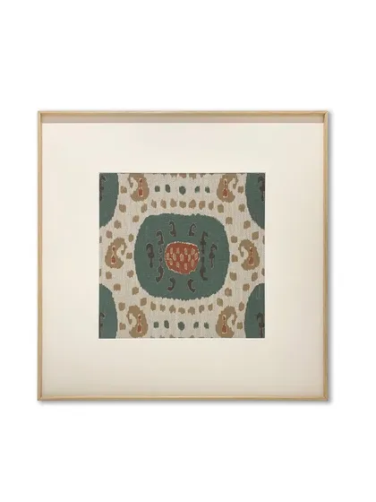 A single, beautiful section of a rug, framed with a wide, off-white mat and a thin metal frame with a wood-like finish. This classic presentation elevates the textile, making it feel like a fine art print.