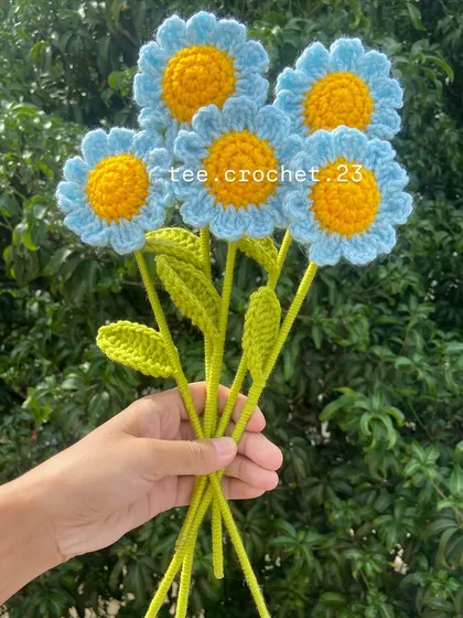 A small bouquet of light blue stuffed daisies, a unique and soft flower option.