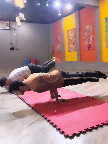 Two students practice the Mayurasana (Peacock Pose), an advanced calisthenics posture that requires significant strength and balance. This shows the level of skill my dedicated students can achieve through consistent training.