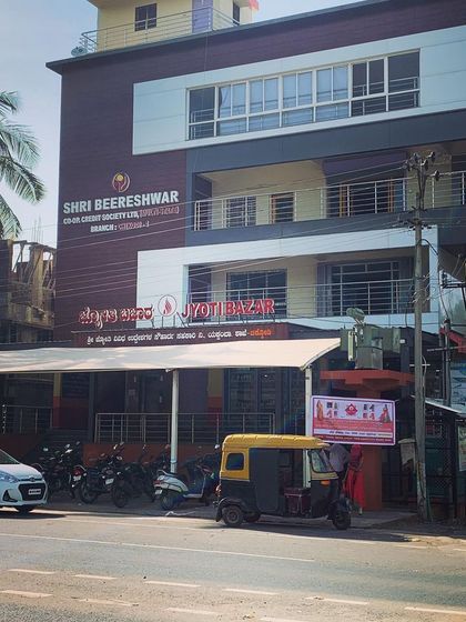 The completed facade of the Shri Beereshwar Credit Society building in Chikodi. The design uses a clean combination of dark and light ACP panels to modernize the building's exterior.