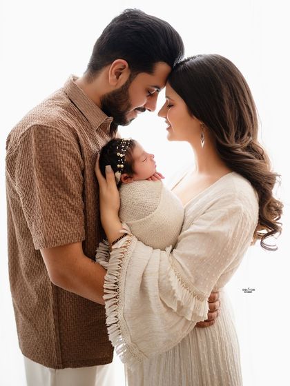 Those first family portraits are so incredibly special. This photo captures the tender moment between new parents as they admire their precious newborn baby.