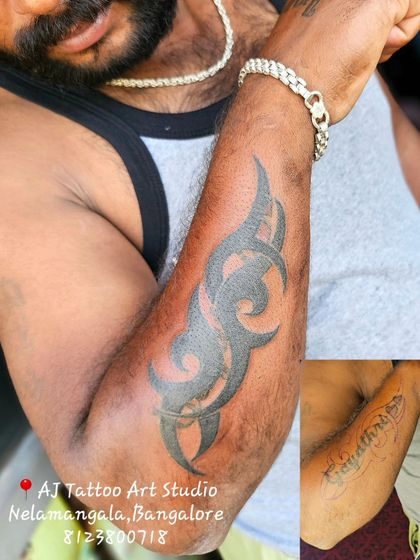 This client wanted to cover an old name tattoo on his bicep. I designed a bold tribal piece that completely concealed it.