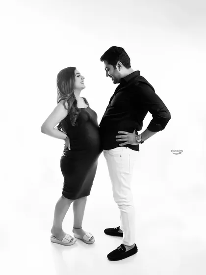 A playful and fun black and white shot with the couple comparing their 'bumps'. This pose always brings out laughter and shows the fun side of the pregnancy journey together.