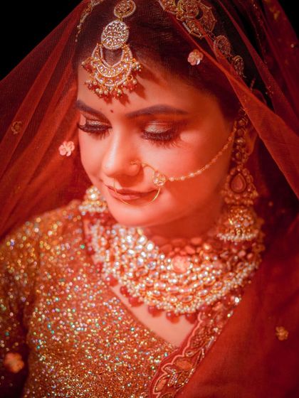 A close-up portrait with a soft, warm glow, highlighting the bride's jewelry and gentle expression.