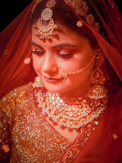 A classic bridal portrait with a soft, warm glow, capturing the texture of the shimmery golden outfit.