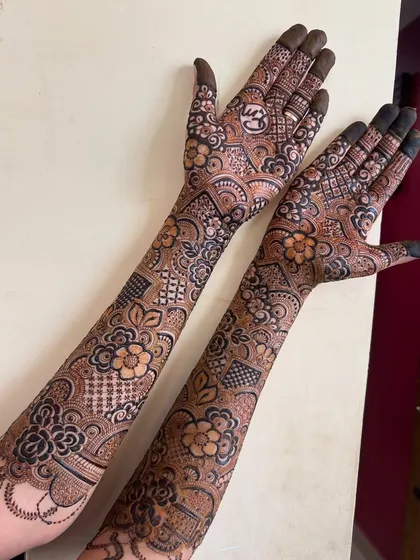 A clear shot of the back of the hands, where you can see the initial 'S' nestled among the flowers.