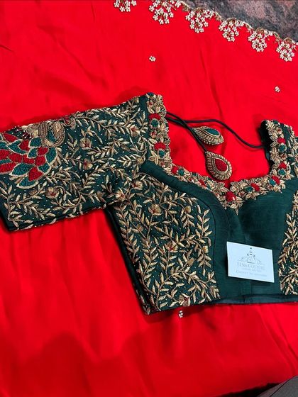 A classic combination of bottle green and red for a bridal look. This blouse is crafted with intricate gold zardozi work in a leafy pattern, with pops of red embroidery to match the saree.