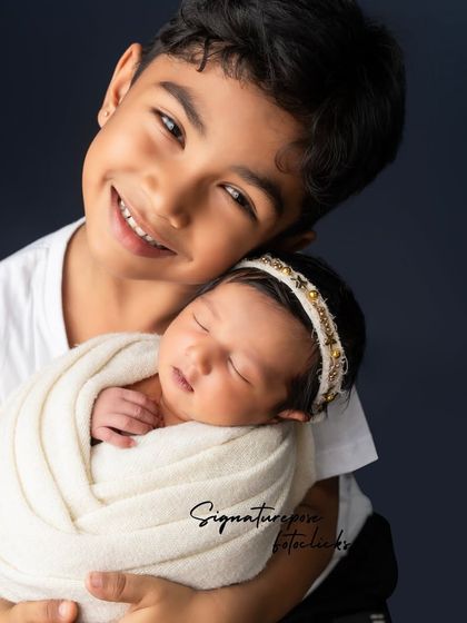 A big brother's proud and gentle hug for his newborn sibling. Capturing the beginning of a lifelong bond is one of our greatest joys.
