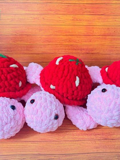 A group of my velvety yarn tortoises with strawberry-themed shells. The plush yarn gives them a lovely, soft texture.