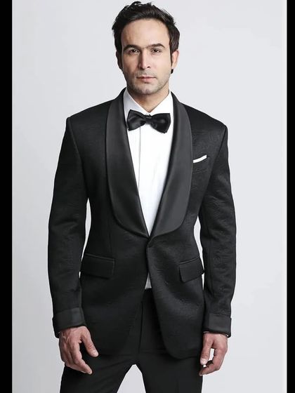 A classic black tuxedo with a textured fabric and a shawl lapel. This is the epitome of timeless elegance, a must-have for any formal affair.