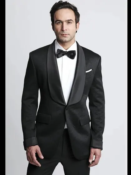 A model in a classic black tuxedo with a shawl collar. This is the epitome of timeless elegance, a must-have for any formal occasion.