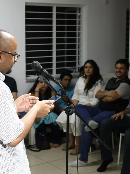An artist engages the audience, who are seated close for an intimate experience.