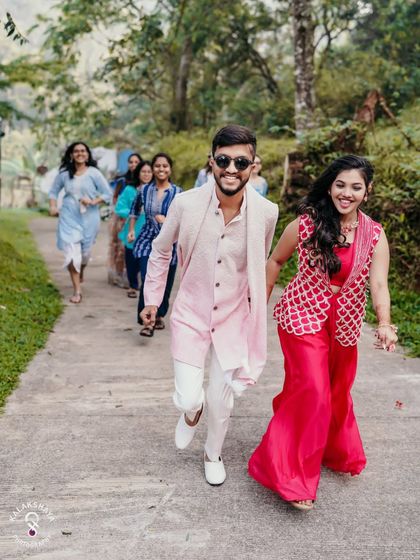The couple and their friends running and laughing, a perfect candid moment from an outdoor Haldi event.