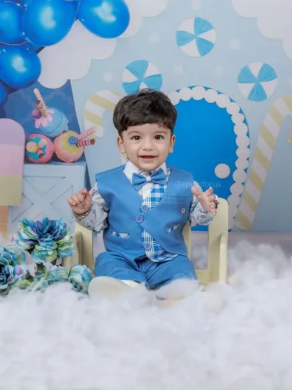 Dressed in a smart blue suit, this little gentleman celebrates his first birthday. Our candy-themed setup creates a sweet and whimsical backdrop for this milestone portrait.