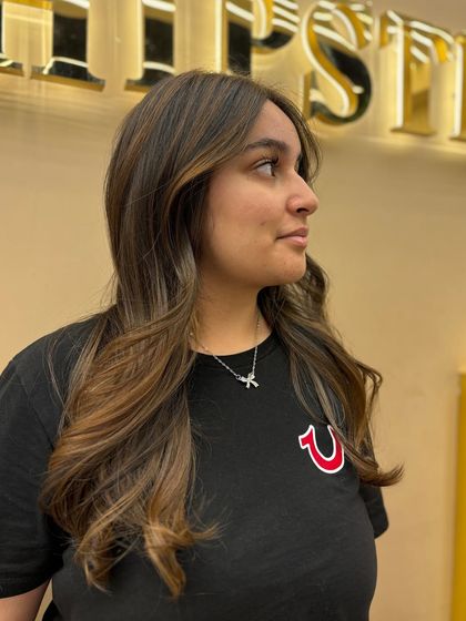 A side profile of a client with her new balayage. The color is perfectly blended to create a seamless, sun-kissed look.