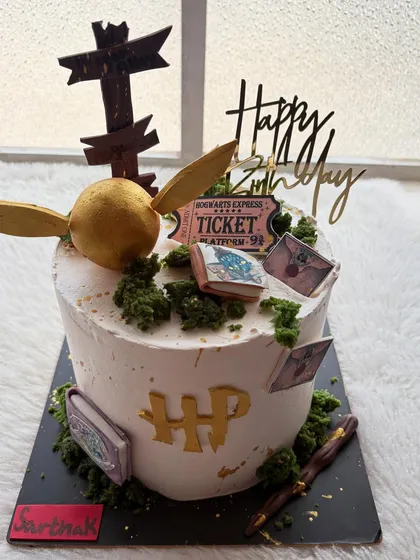 A magical Harry Potter-themed cake, complete with a ticket to Hogwarts, a golden snitch, and little spellbooks. Perfect for any Potterhead's birthday.