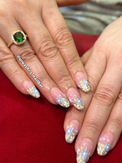 A dreamy, feminine design with delicate 3D-style pastel blossoms. The flowers are set against a shimmery, soft gradient base, giving the manicure a gentle yet luxurious feel perfect for spring.