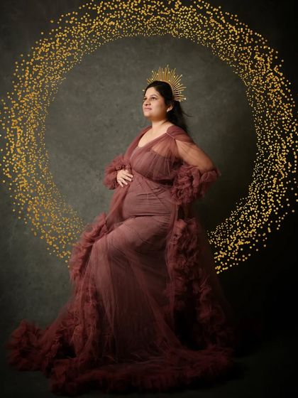 Adding a touch of digital magic, a golden sparkling ring of light completes this majestic and artistic maternity portrait.