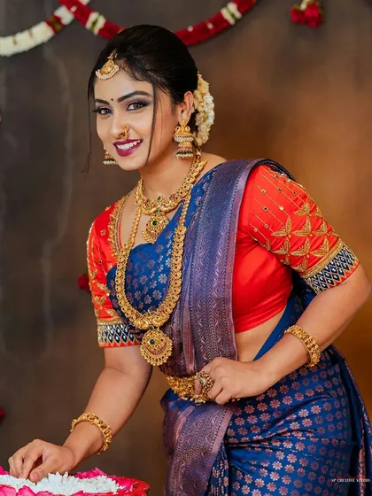 A confident and beautiful pose from a model during a collaborative photoshoot, highlighting a stunning blue and red saree.
