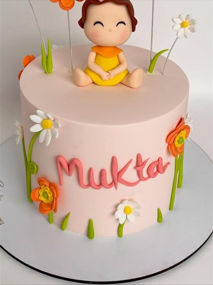 Another angle of Mukta's birthday cake, showing the placement of the flowers and the personalized name in a playful font.