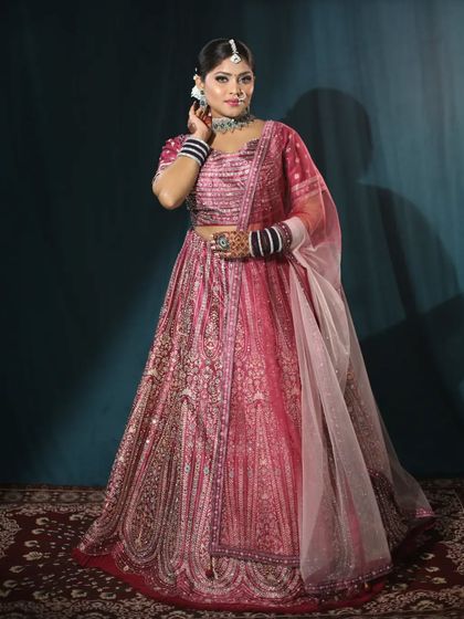 Another angle of this pink bridal lehenga, showing the intricate work on the blouse and the delicate net dupatta. Every detail is carefully considered.