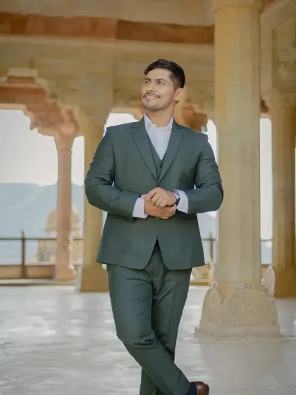 A dapper solo portrait of the groom in a stylish suit, taken within the corridors of Amber Fort. I ensure both partners get their moment to shine during the pre-wedding shoot.